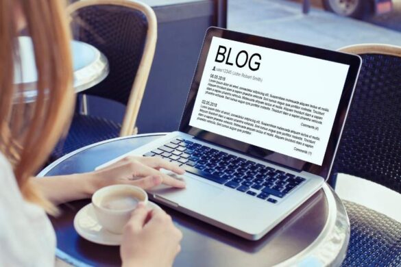 Laptop displaying blog page while person holds coffee, representing blogging trends