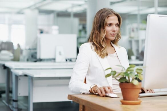 Professional woman working at computer focused on maximizing efficiency