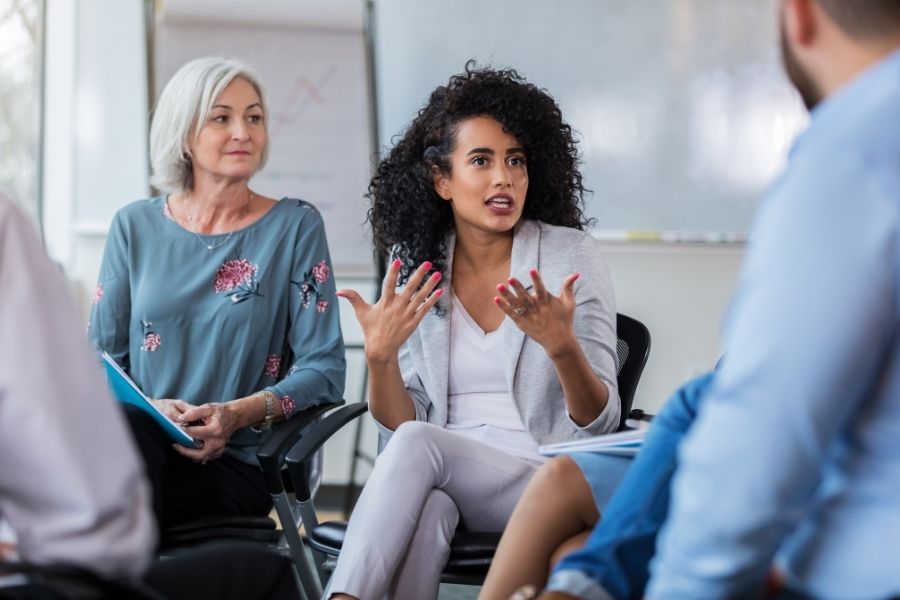 Diverse group holding colorful speech bubbles representing shaping public opinion through social communication