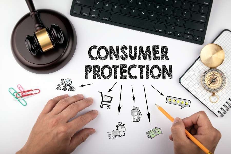 Hands drawing consumer protection laws diagram with gavel and keyboard showing legal framework