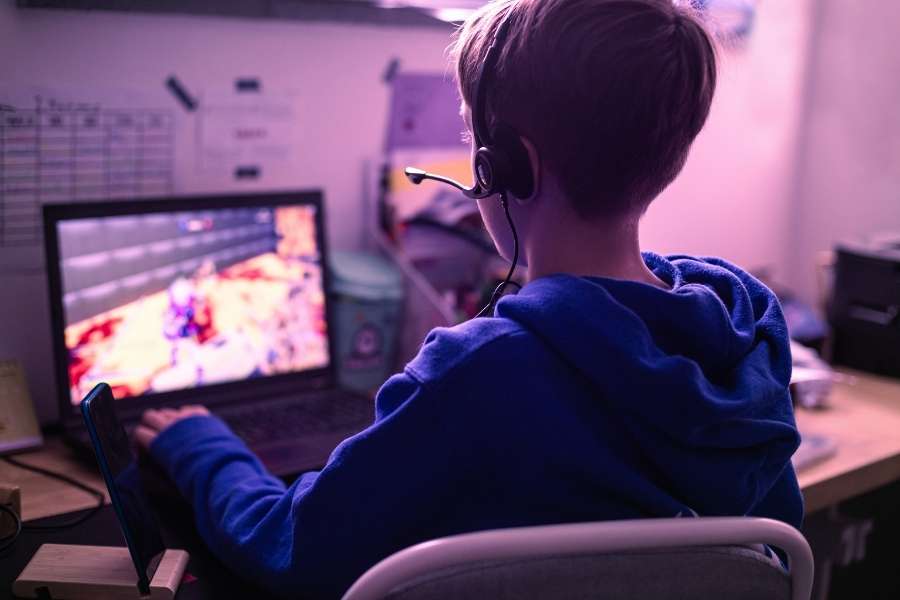 Young gamer with headset playing online video games connecting with gaming communities