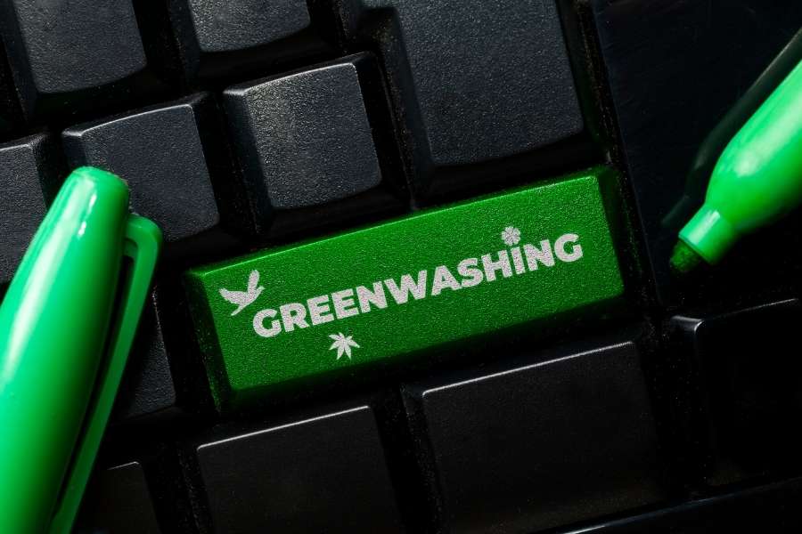 Computer keyboard with green "GREENWASHING" key highlighting digital greenwashing warning signs