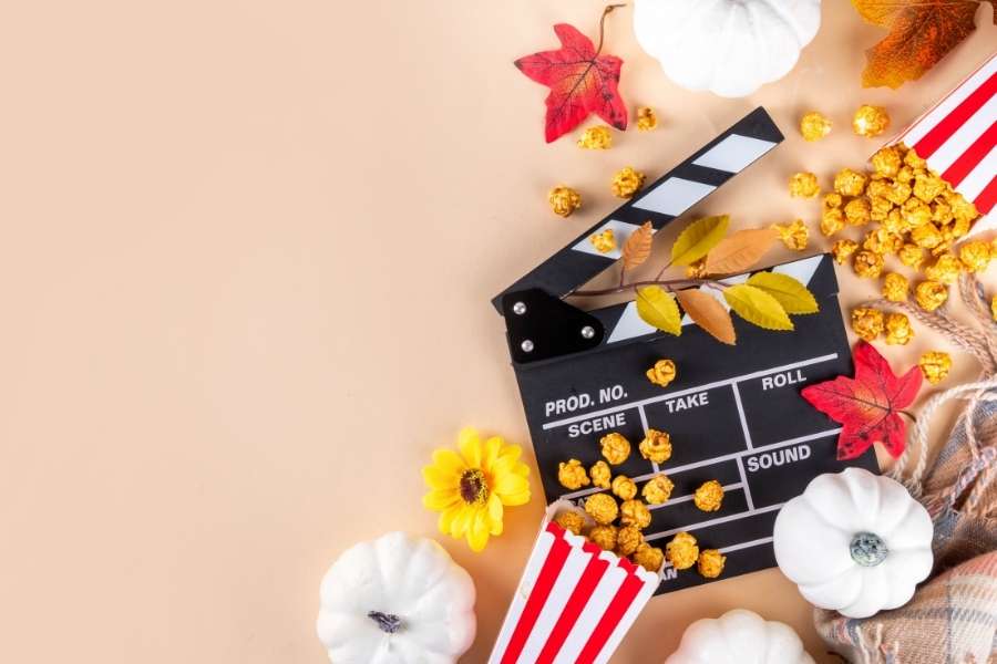 Autumn movie night setup with seasonal eating patterns featuring pumpkins, popcorn, and fall decorations